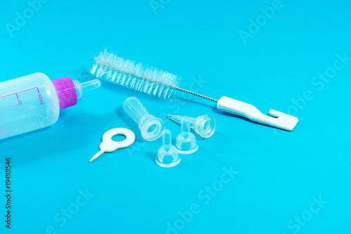 Pet accessories concept: Bottle feeding for pet and cleansing tools on blue background.