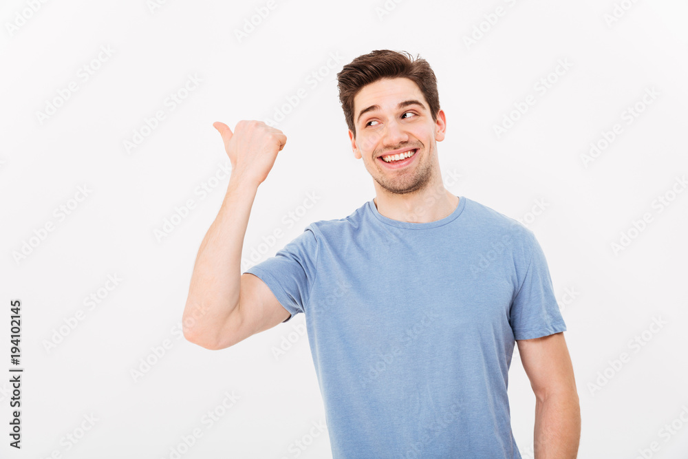 Closeup image of man with shining smile in casual clothing pointing finger aside on copyspace text or product, isolated over white background Closeup image of man with shining smile in casual clothing pointing finger aside on copyspace text or product, isolated over white background
