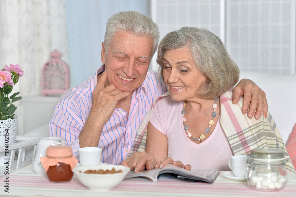 Senior couple drinking tea and reading magazine Senior couple drinking tea and reading magazine