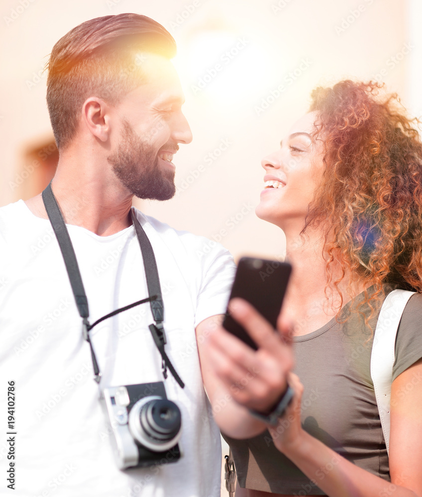 Smiling couple using smart phone together in city Smiling couple using smart phone together in city