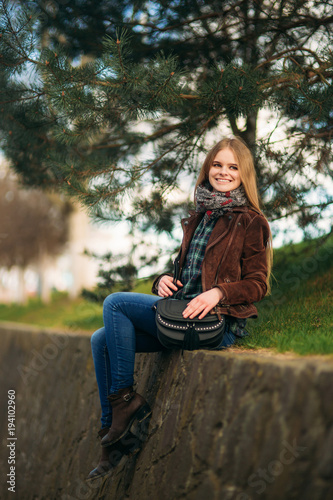 Blond girl walking in the park. Posing to the photographer.