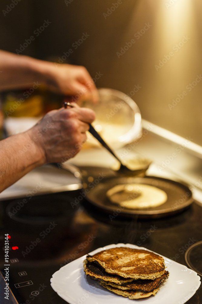 MAN COOKING PANCAKES ON COOKER RANGE MAN COOKING PANCAKES ON COOKER RANGE