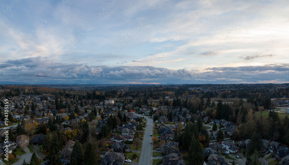 Obraz premium Aerial panoramic view of a suburban neighborhood during a vibrant and cloudy sunset. Taken in Greater Vancouver, British Columbia, Canada.