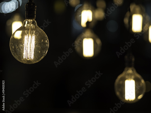 Filament antique looking light bulbs hanging from ceiling and black copy space