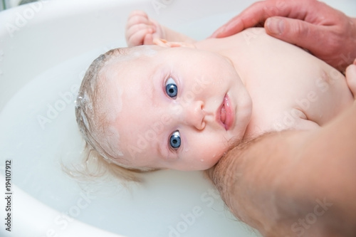 Bathing funny baby in the tub.