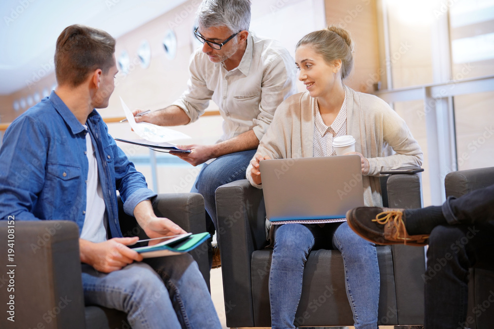 Obraz premium Group of students in lounge room with teacher