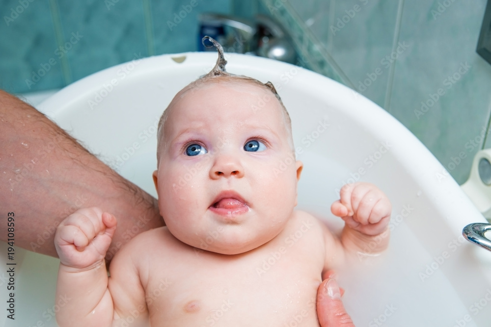 Bathing funny baby in the tub.