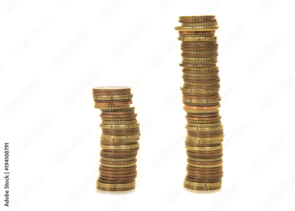 Two stacks of used coins representing double sales or income isolated on a white background Two stacks of used coins representing double sales or income isolated on a white background