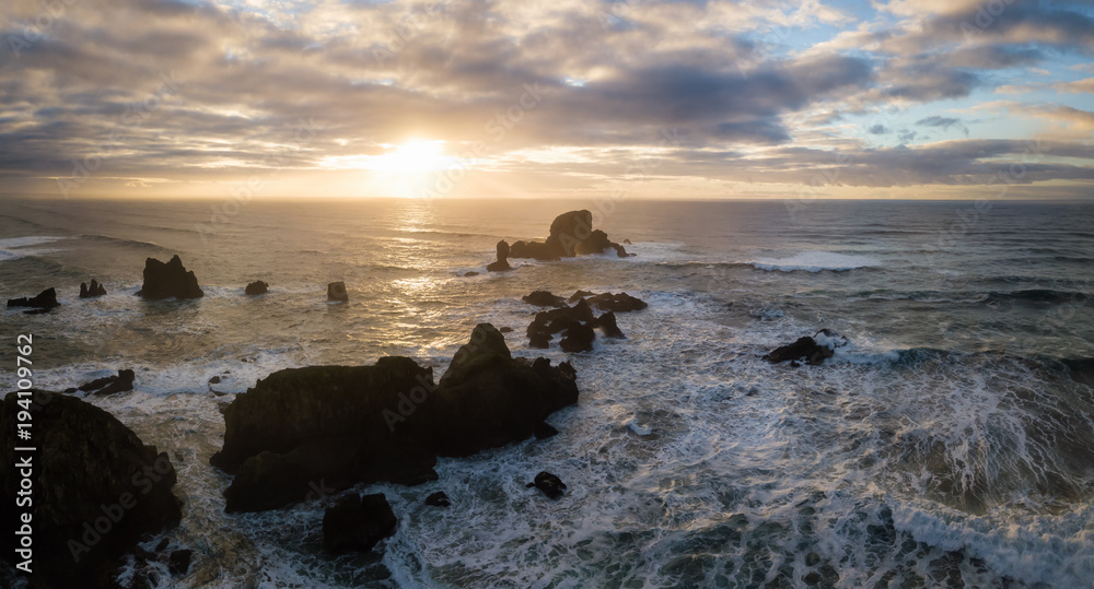 Striking and Dramatic Panoramic Aerial View of the Rock Pacific Ocean during a Vibrant Winter Sunset. Taken in Oregon Coast, North America.