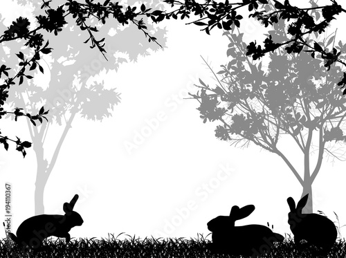 rabbit three black silhouettes in grass under blossoming branches