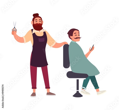 Cute bearded male hairdresser cutting hair of his client sitting in chair and...