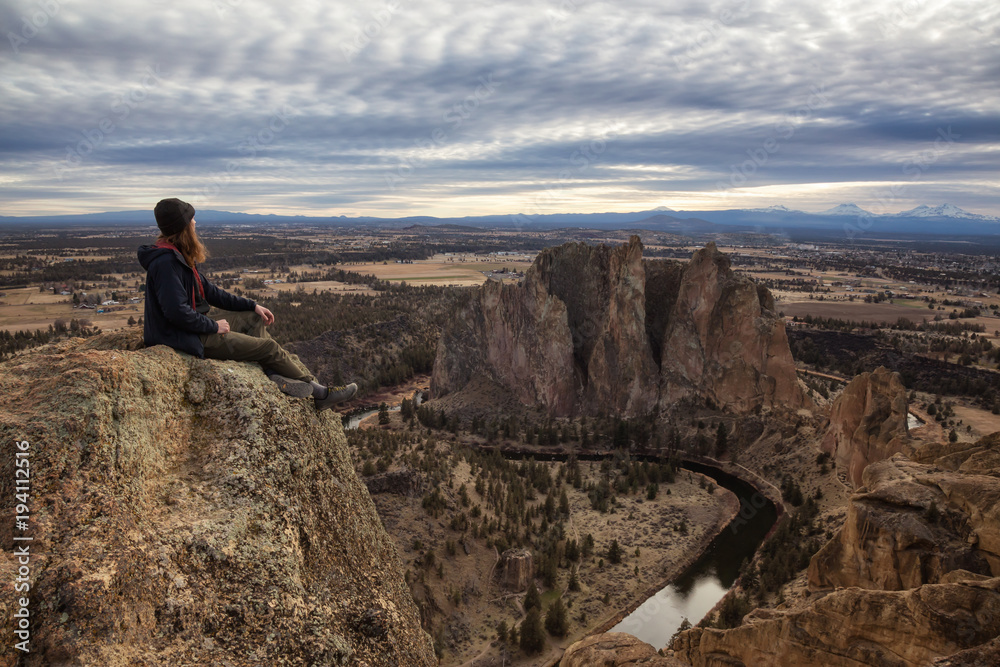 Man enjoying the Beautiful American Mountain Landscape during a vibrant winter day. Taken in Smith Rock, Redmond, Oregon, America. Concept: Adventure, Holiday and Travel