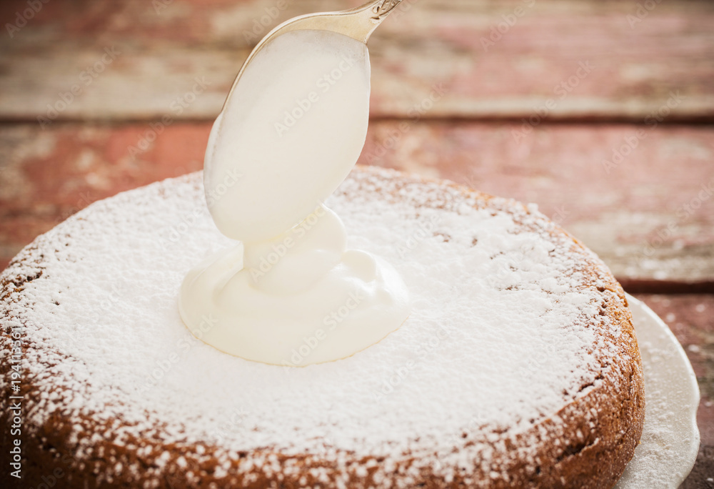 overlaying cream on a sponge cake