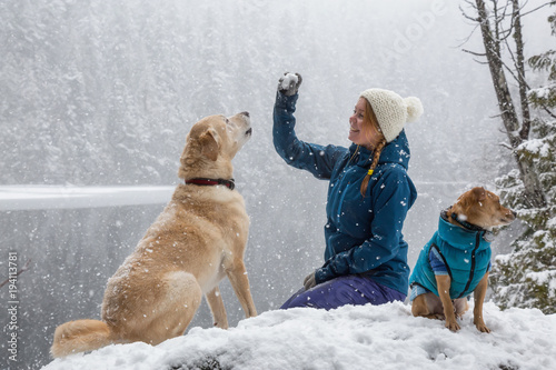 Girl playing with her dog in the snow. Taken near Squamish and Whistler, North of Vancouver, BC Canada. Concept: love, friendship, care
