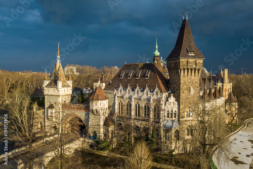 Budapest, Hungary - Aerial view of beautiful Vajdahunyad Castle in City Park at sunset with dark clouds behind at winter time