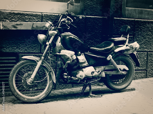 old black and white motorcycle parked in the roadside