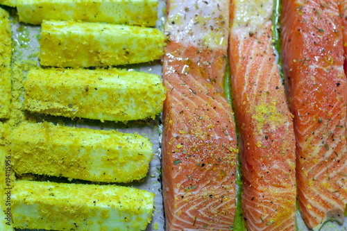fresh salmon with zucchini on baking paper, ready for cooking