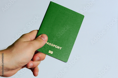 Green passport in the hands of a man on a white background.  Isolate