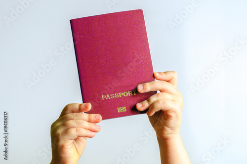 Red  passport in the hands of the child. Isolate