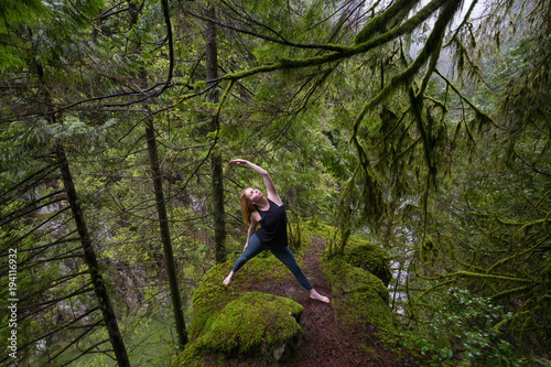 Young Caucasian Girl is practicing yoga in the rain forest. Taken in Capilano Canyon, North Vancouver, BC, Canada.