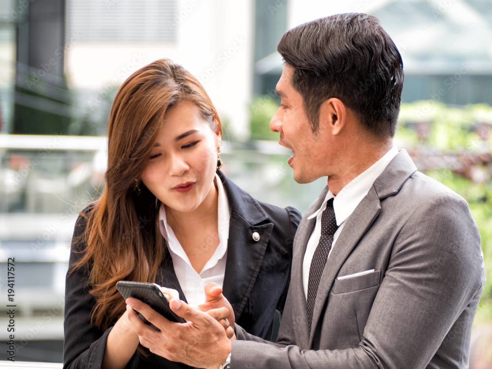 Happy business man and business woman using smartphone app for e business Happy business man and business woman using smartphone app for e business