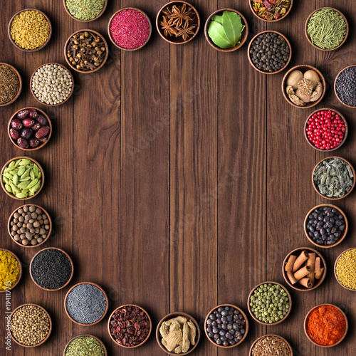 Herbs and spices over wooden table background. multicolored seasoning,top view with copy space
