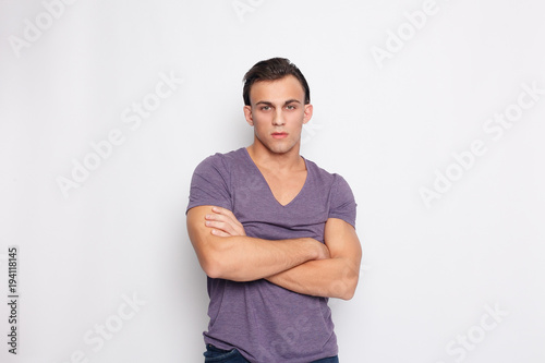 Handsome young man on grey background looking at camera