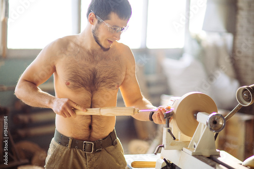 wood lathe, lathe naked operator working a wood pestle photo