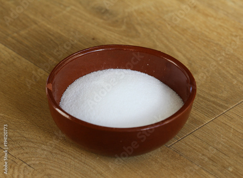 bowl with white salt on wooden background