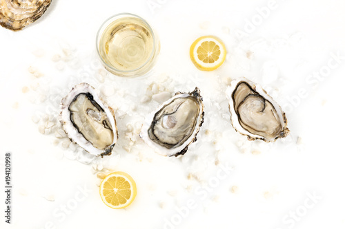 Overhead photo of three oysters with wine, lemon, and copy space photo
