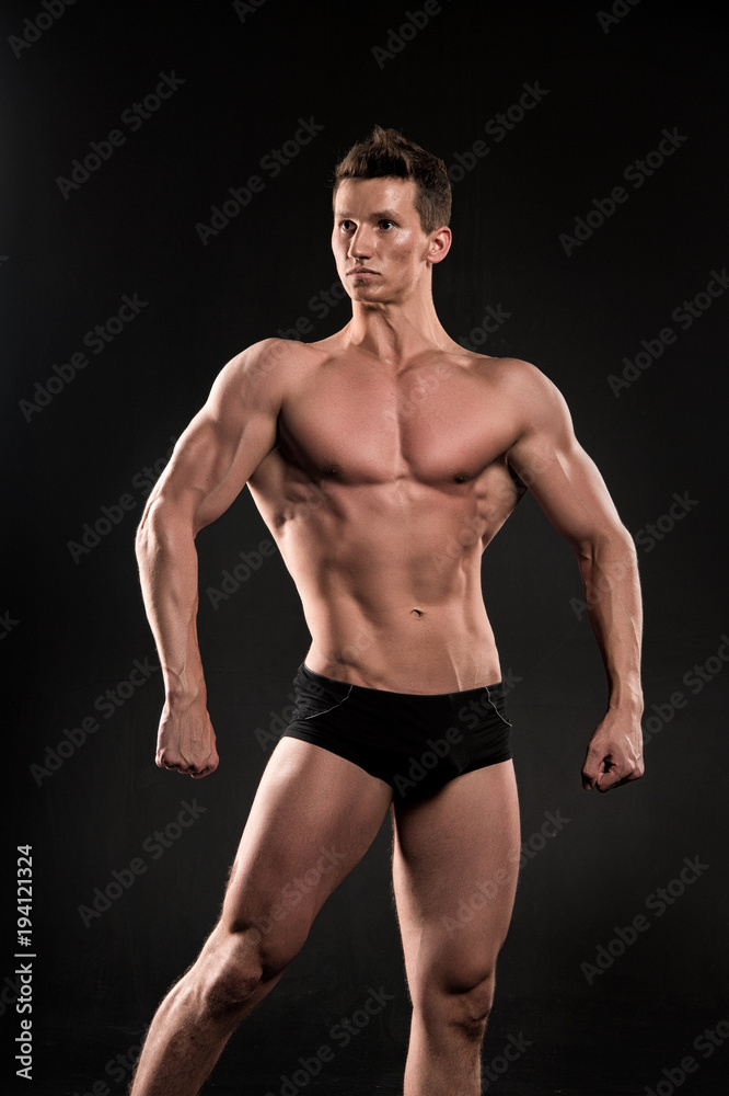 Man athlete show muscular body on dark background