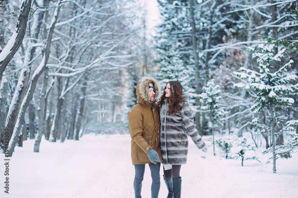 Naklejka premium Guy and girl walk ,have fun in the forest in winter