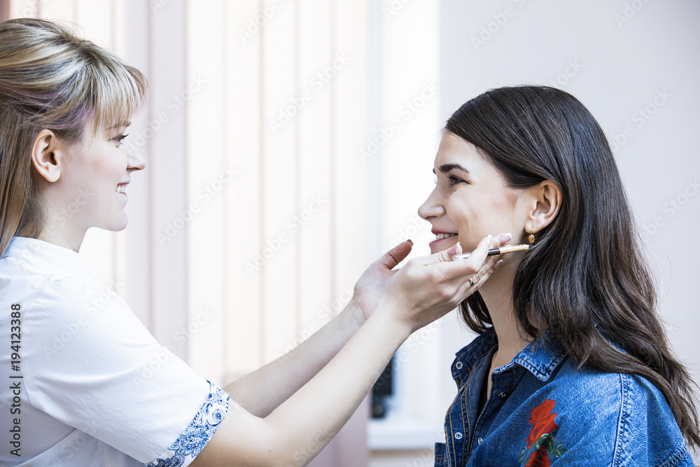 Beautician female carries out the correction of eyebrows on beautiful models in cosmetic cabinete Beautician female carries out the correction of eyebrows on beautiful models in cosmetic cabinete