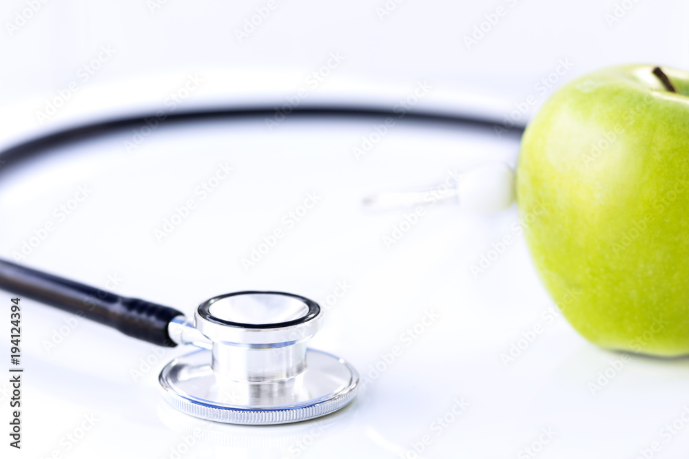 Stethoscope and green apple isolated on white table background. Stethoscope and green apple isolated on white table background.