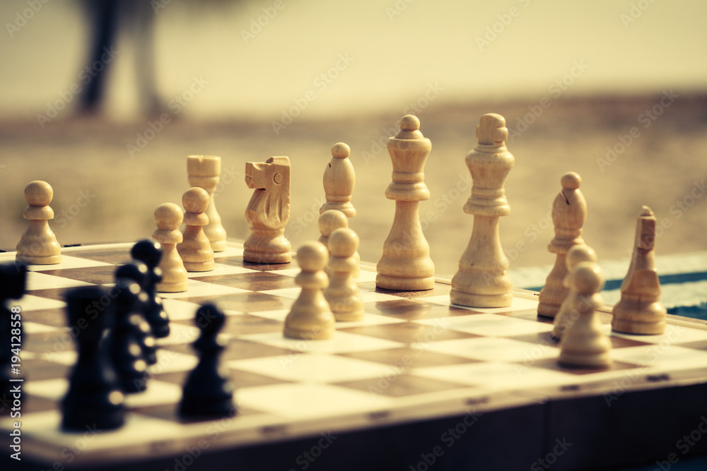 Close up white and black wooden chess pieces on board Close up white and black wooden chess pieces on board