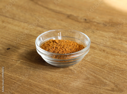 Glass bowl with hot cajun seasoning on wooden background