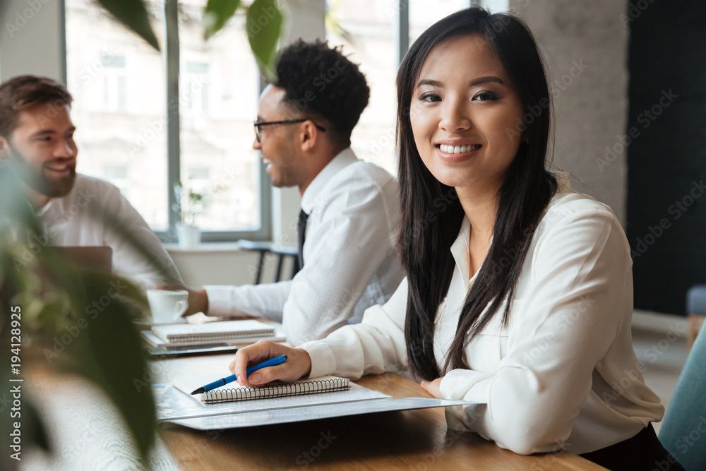 Cheerful young asian businesswoman near colleagues. Cheerful young asian businesswoman near colleagues.