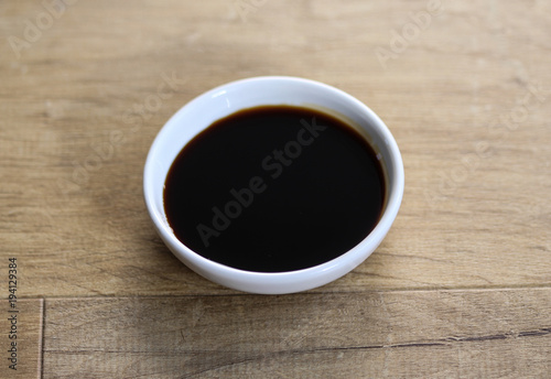 white bowl with sweet soy sauce on wooden background