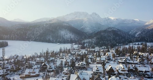 aerial view of a small snowy town and mountains in winter