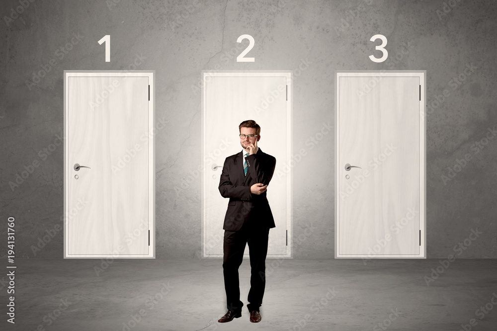 Fototapeta premium Businessman thinking in front of three doors