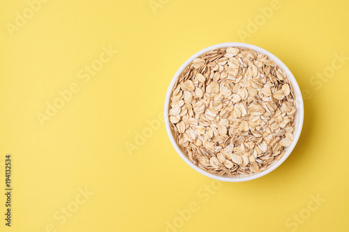 Muesli for breakfast. Healthy food. Yellow background. Many flakes photo