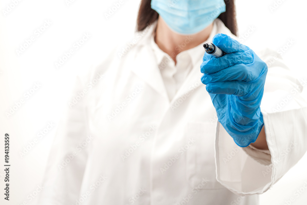 Naklejka premium Medical diagnostic and communicating outbreak information concept with a female doctor writing with a black marker, the woman is wearing a white lab coat, surgical gloves and a mask with copy space