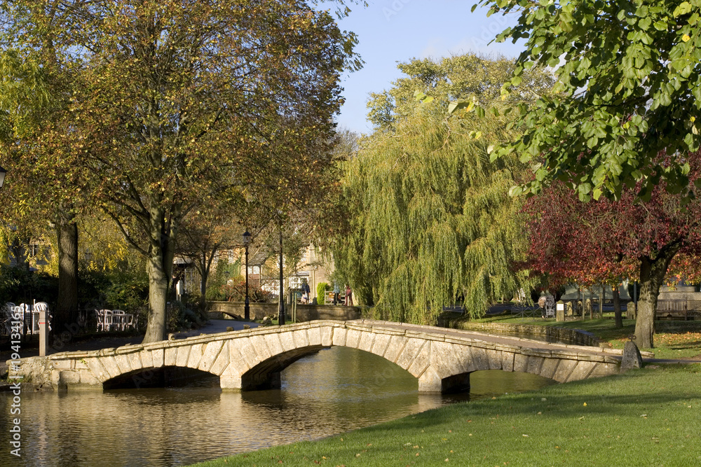 England, Gloucestershire, Cotswolds, Bourton on the Water, River Windrush, autumn colour, autumn sunshine