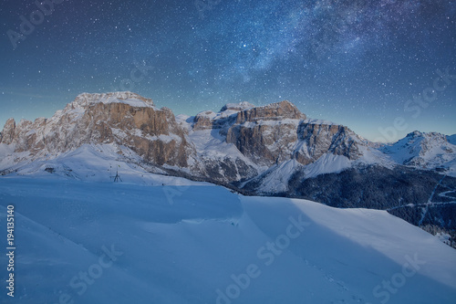 Fantastic starry sky. Panoramic view of the Val Di Fassa ski resort of the Italian Dolomites under starry light