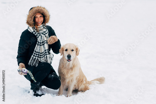 Photo of smiling girl with dog in winter park