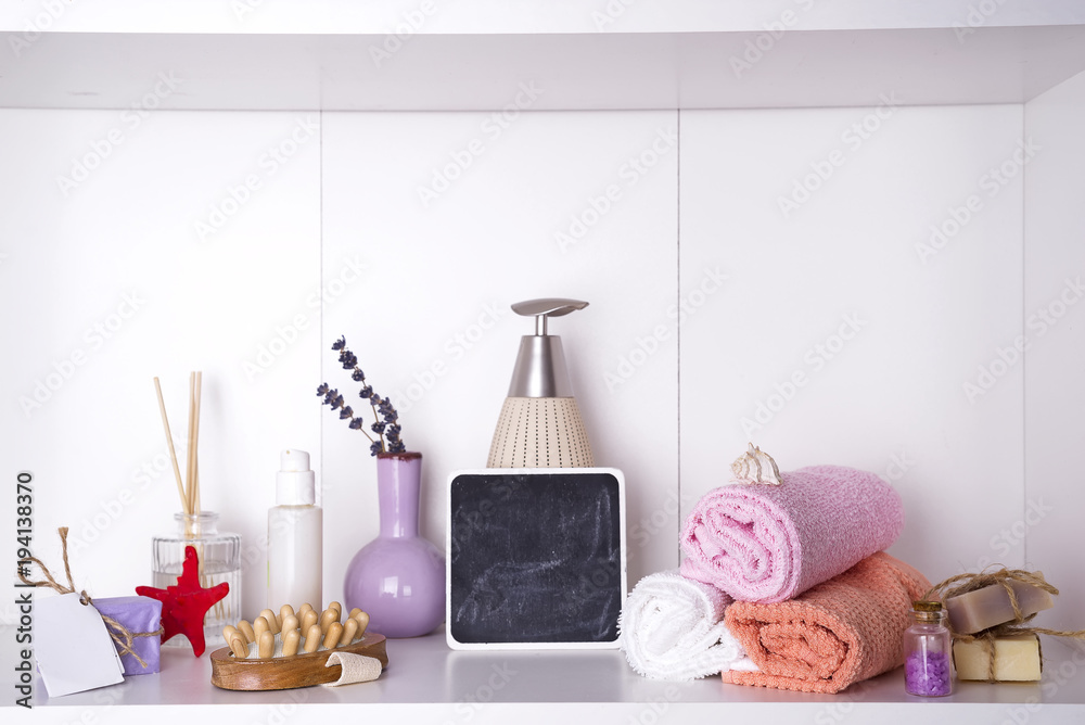 towels in a wooden tray with aroma chopsticks, candles, massage washcloths and a bottle with a dispenser towels in a wooden tray with aroma chopsticks, candles, massage washcloths and a bottle with a dispenser