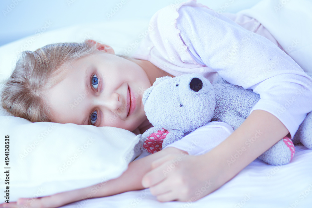 Child little girl sleeps in the bed with a toy teddy bear Child little girl sleeps in the bed with a toy teddy bear