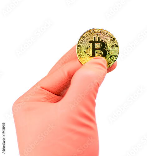 Coin bitcoin in a hand in a glove on a white background. Isolated.