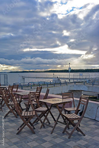 Street open cafe with view at the Volga river, Samara, Russia at sunset. Tables and seats are empty. Romantic evening place. © annettbro