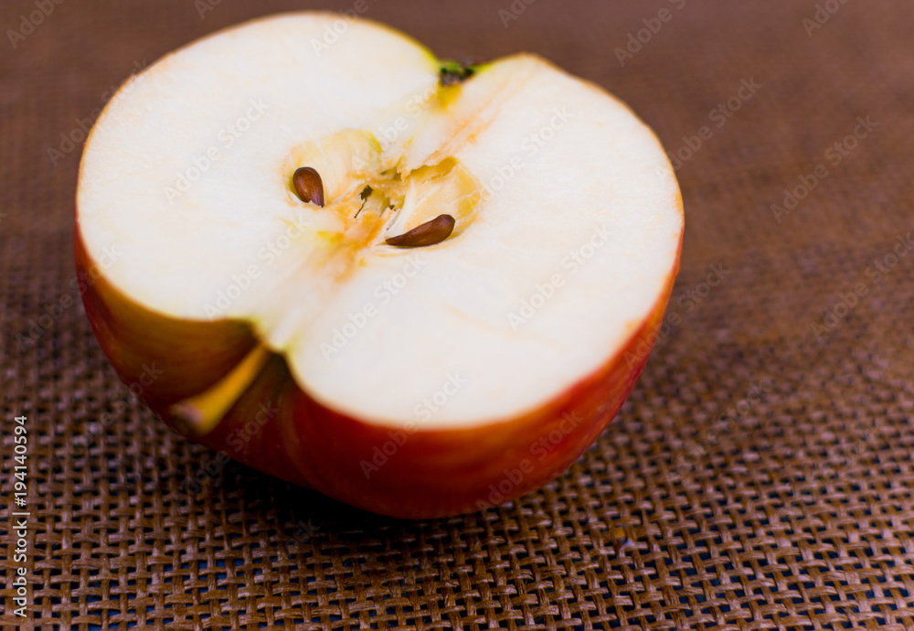 Half an apple on a dark brown background.